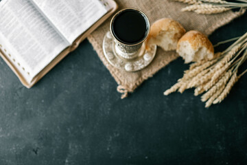 Cup with wine, bread and open Bible, Christian communion