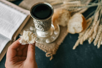 Cup with wine, bread and open Bible, Christian communion