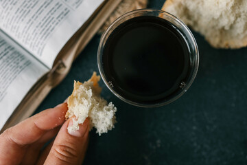 Cup with wine, bread and open Bible, Christian communion