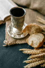 Cup with wine, bread and open Bible, Christian communion