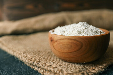 Flour in a wooden bowl on burlap