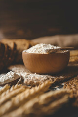 Flour in a wooden bowl, fresh homemade bread and ears of corn, bakery banner