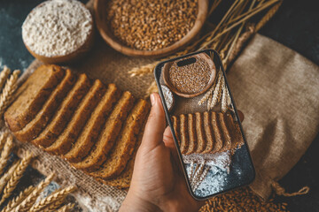 Phone in hand with photo of bread - Powered by Adobe