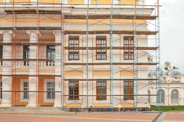 Scaffolding on a generic old tenement house, renovated historical building facade detail, closeup,...