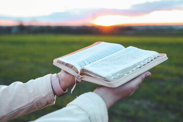 Open bible in hands close-up, concept of calmness and morning solitude