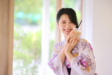 Japanese woman smile with yukata dress and milk tea in hand