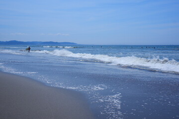 きらきら輝く夏の海で、サーファーがサーフィンを楽しむ夏のイメージ

