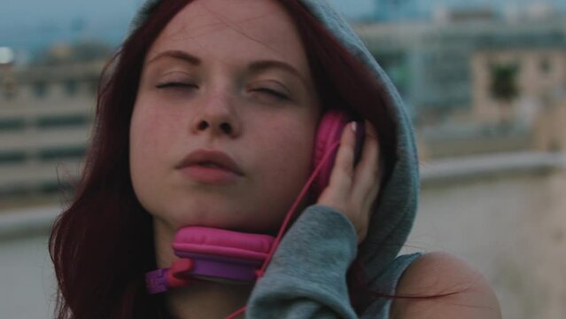 Woman holding headphones on ear with hoodie