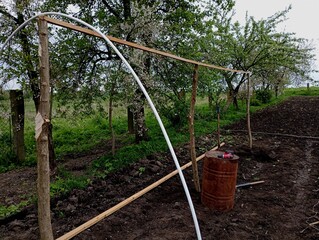A wooden frame that supports pipes over which polyethylene film will be stretched to create a...