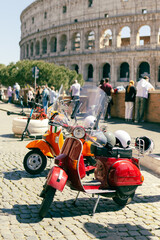 Two Retro scooters stay near the Roman Coliseum. One of the most popular travel place in world,...