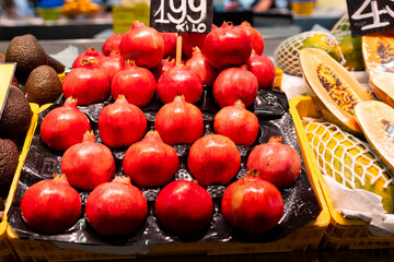 Fresh fruits on shelf in market. Healthy and food concept. Fresh red pomegranates at farmer's market