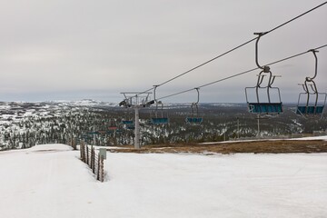 Ski lifts at Kaunispää fell slope in cloudy spring weather, Lapland, Finland.