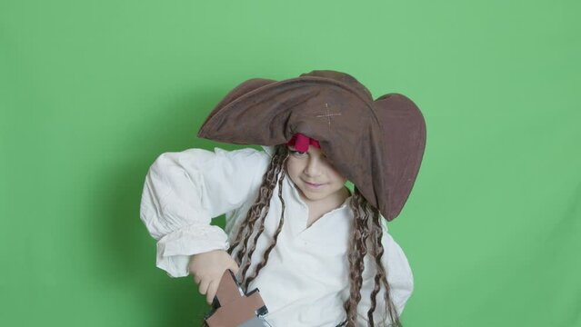 Cute child pirate taking cutlass and slicing through the air solated on green screen. High quality 4k footage