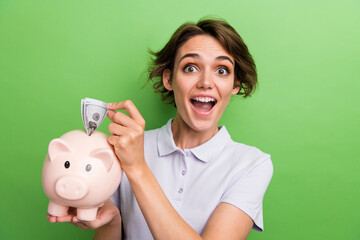 Creative concept of business worker young girl collect savings put dollar banknote inside piggy...