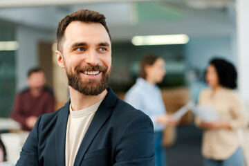 Portrait of happy bearded man businessman, manager working in modern office, looking away copy space