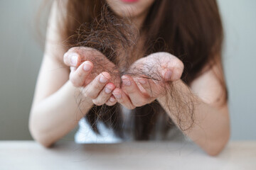 Serious, worried asian young woman, girl holding, show damaged loss hair, problem after brushing,...