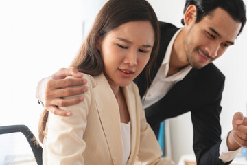 Disgusted asian young employee, pressure business woman uncomfortable, looking hand of boss or colleague when touching her shoulder, embrace. Sexual harassment inappropriate at office, workplace.