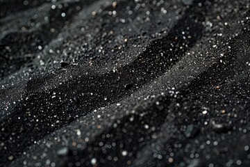 Detailed close-up of black surface with mini water droplets accentuating its texture and hue variations