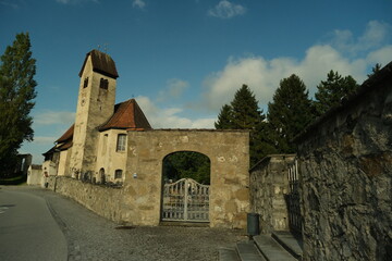 A stone building with a clock tower and a gate