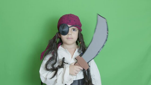 Cute child pirate taking cutlass and slicing through the air solated on green screen. High quality 4k footage
