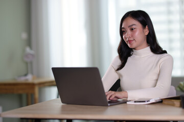 Young beautiful Asian woman working at home.