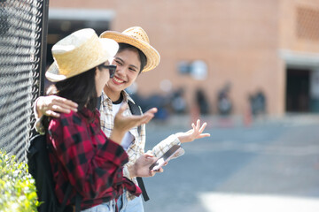 Two Asian female tourists walking on a tourist street in Bangkok, Thailand.