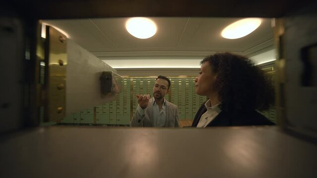 Sales Agent Talking to Customer Inside Safe Vault Room Explaining Deposit