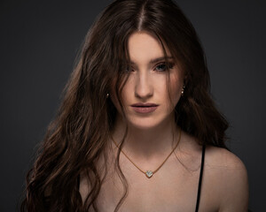 Naklejka premium Beauty studio portrait of young beautiful woman against gray background.