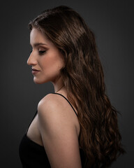 Beauty studio portrait of young beautiful woman against gray background.