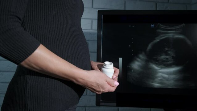 Abortion. Woman hold birth control pills. A view of female hands with a bottle with birth control medications indoor.