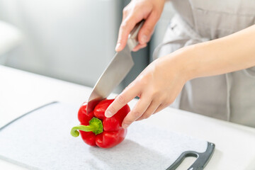 包丁で野菜を切る女性の手元・料理イメージ