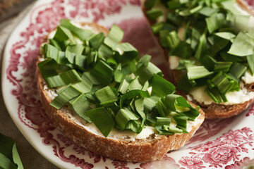 Fresh wild garlic or ramson leaves on a slice of sourdough bread with butter