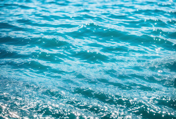 Fototapeta premium Crystal-clear water waves with detailed sunlight reflections enhancing serene blue tones.. AI generated.