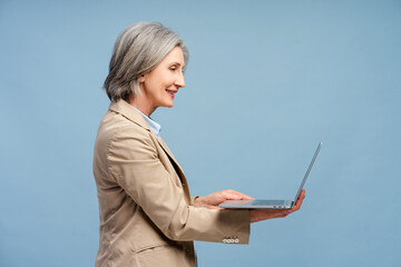 Smiling gray haired senior woman holding laptop computer working online isolated