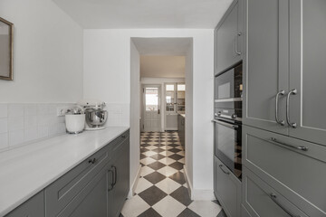 Baking area of ​​a farmhouse style kitchen with white marble countertop, and storage cabinets