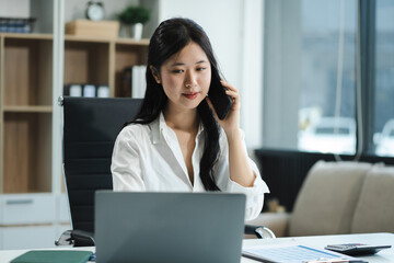 Businessman using laptop computer and smartphone  in office. Happy woman, entrepreneur, small business owner working online.