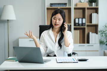 Businessman using laptop computer and smartphone  in office. Happy woman, entrepreneur, small business owner working online.