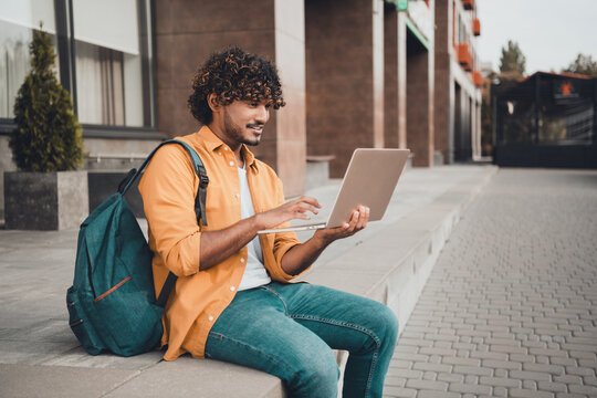 Photo of confident clever young man it specialist sitting working using modern device wireless device connection autumn day outdoor