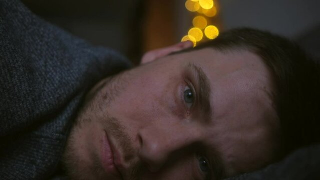 Depression man lying on bed, he is disappointment, he looks indifferently at one point. Slowmotion.
