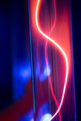 A purple and blue glowing tube with a red line running through it. The tube is lit up and he is a...