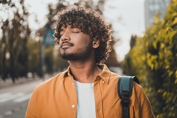 Photo of dreamy peaceful latin man walking enjoying fresh air warm autumn september day sunny...