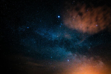 Milky way in the night sky. Long exposure with constellations. Cloud with sahara dust at the edge of the image. Weather phenomenon photographed in spring.