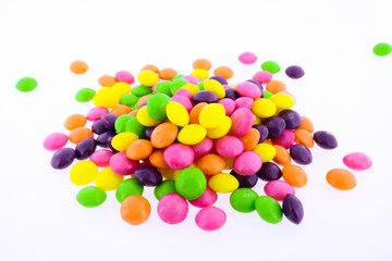 Multi-colored candies poured on a white background