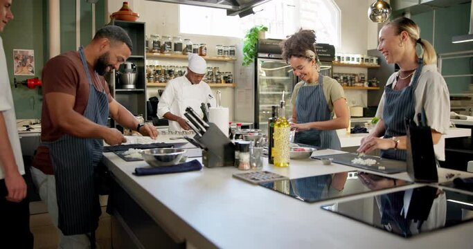 Chef, cooking and teaching in culinary school for education, learning and teamwork with chopping board. Group of people, mentor and students or staff at restaurant for hospitality and food in kitchen