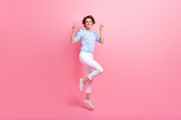 Full length photo of energetic excited person jumping demonstrate v-sign empty space isolated on...