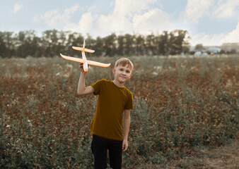 boy teenager child kid standing on field with toy plane his hands