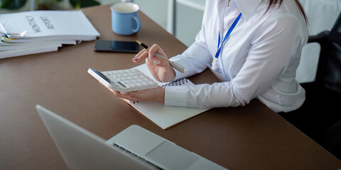 Finance concept. Close up businesswoman hold a graph pen and writing report, and memo, and...