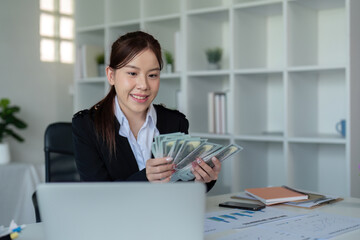 Businesswoman or financial bookkeeper holding bundle of money dollar for payment salary and income....