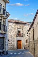 Fototapeta na wymiar Narrow city street leading to Palacio de los Verdugos (1531) in Avila, Spain