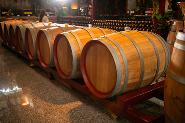 Fototapeta premium Old wooden wine barrels stacked in a cellar in order